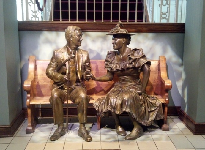 The statues of Roy Acuff and Minnie Pearl seated in the lobby of Ryman Auditorium.