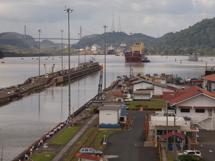 As viewed from the visitor's center, an eastbound container ship approaches the Miraflores locks.