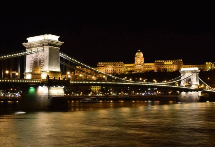 A view of the Chain Bridge at night, with Buda Castle looming in the background.